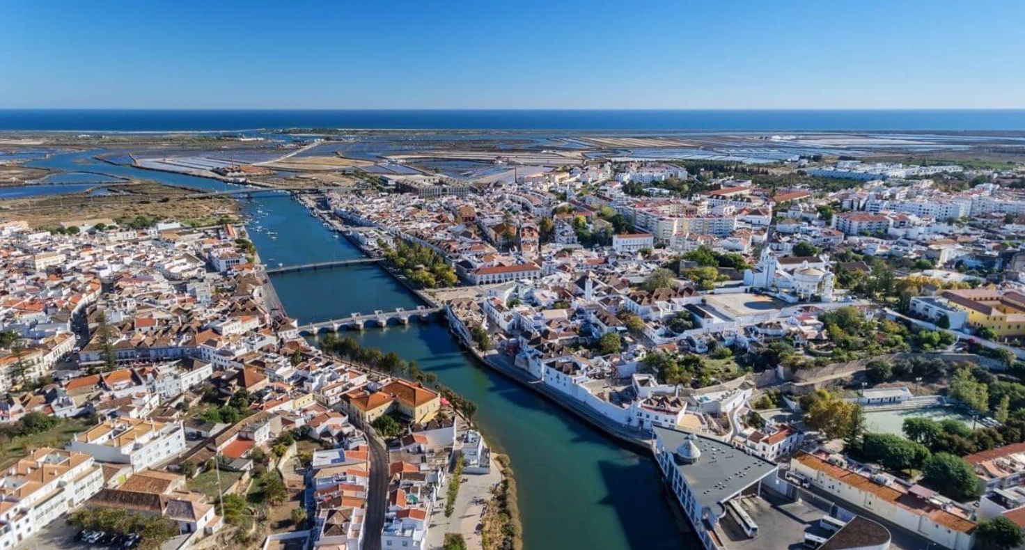 Vista aérea de Tavira com a Ponte Romana e o rio — conformidade de arrendamento de curta duração para proprietários britânicos