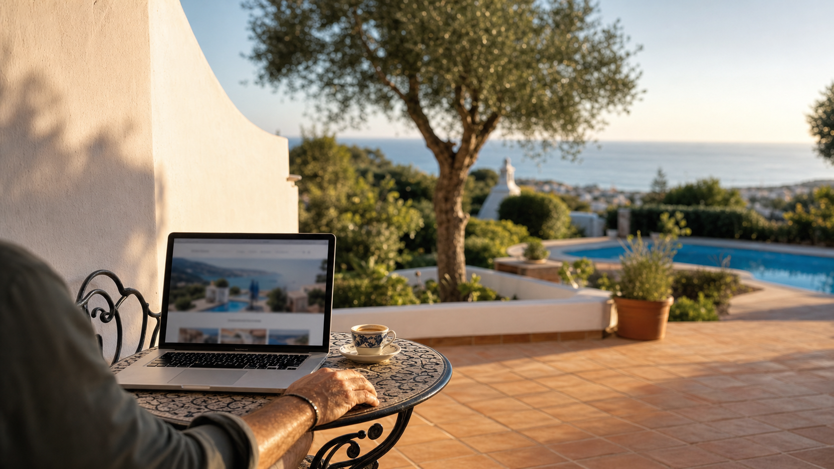 Terraço de villa no Algarve ao entardecer com computador portátil aberto a mostrar um anúncio de arrendamento de curta duração